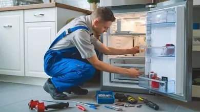 Technician inspecting the interior of a home refrigerator